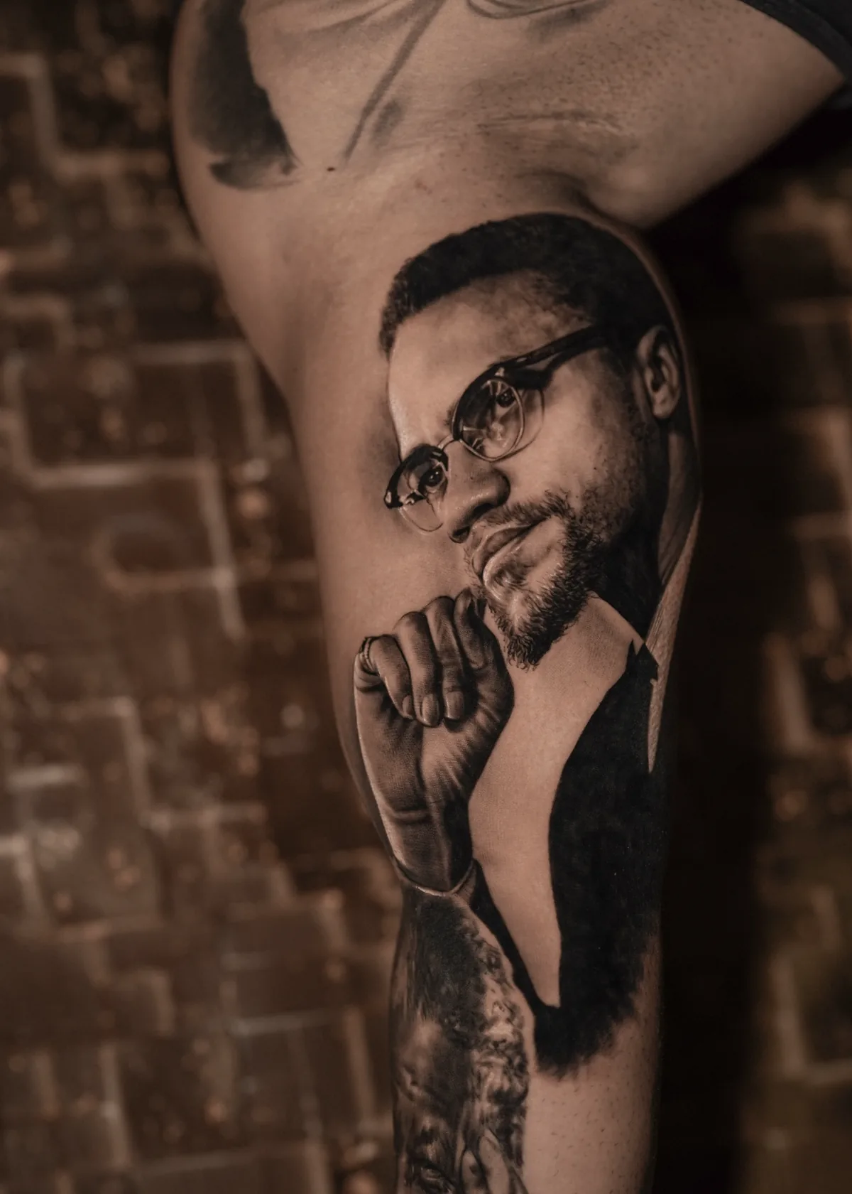 Malcolm X portrait tattoo on thigh by Ramon Rodrigo